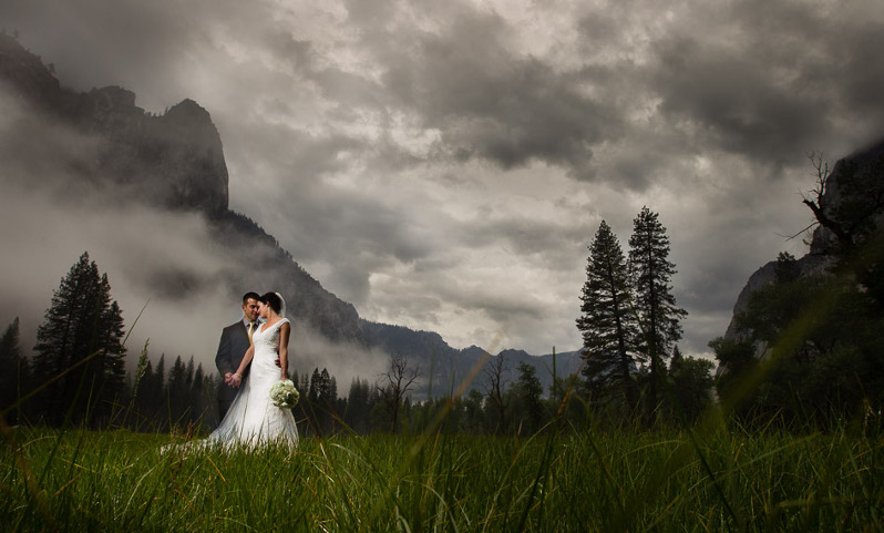 Az ifjú pár hatalmas viharfelhők alatt egy hegy lábánál